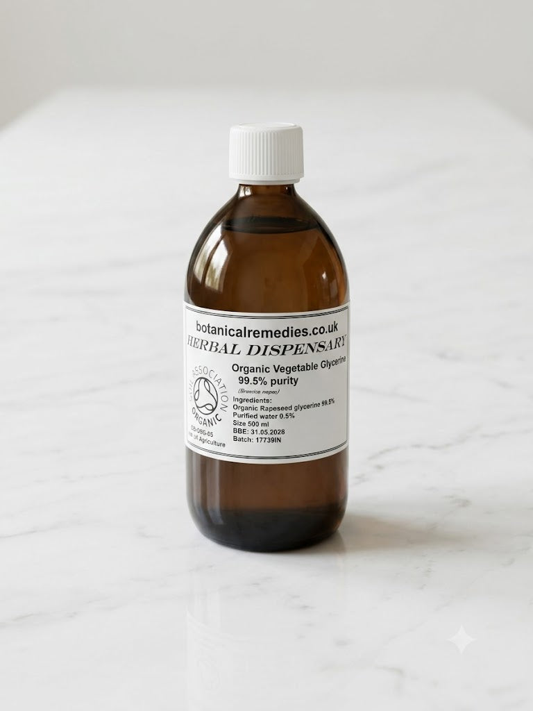 A 500ml amber glass bottle of Soil Association certified Organic Vegetable Glycerine 99.5% purity (Brassica napus) by Botanical Remedies, featuring a white screw cap and standing upright on a minimalistic white marble tabletop background.