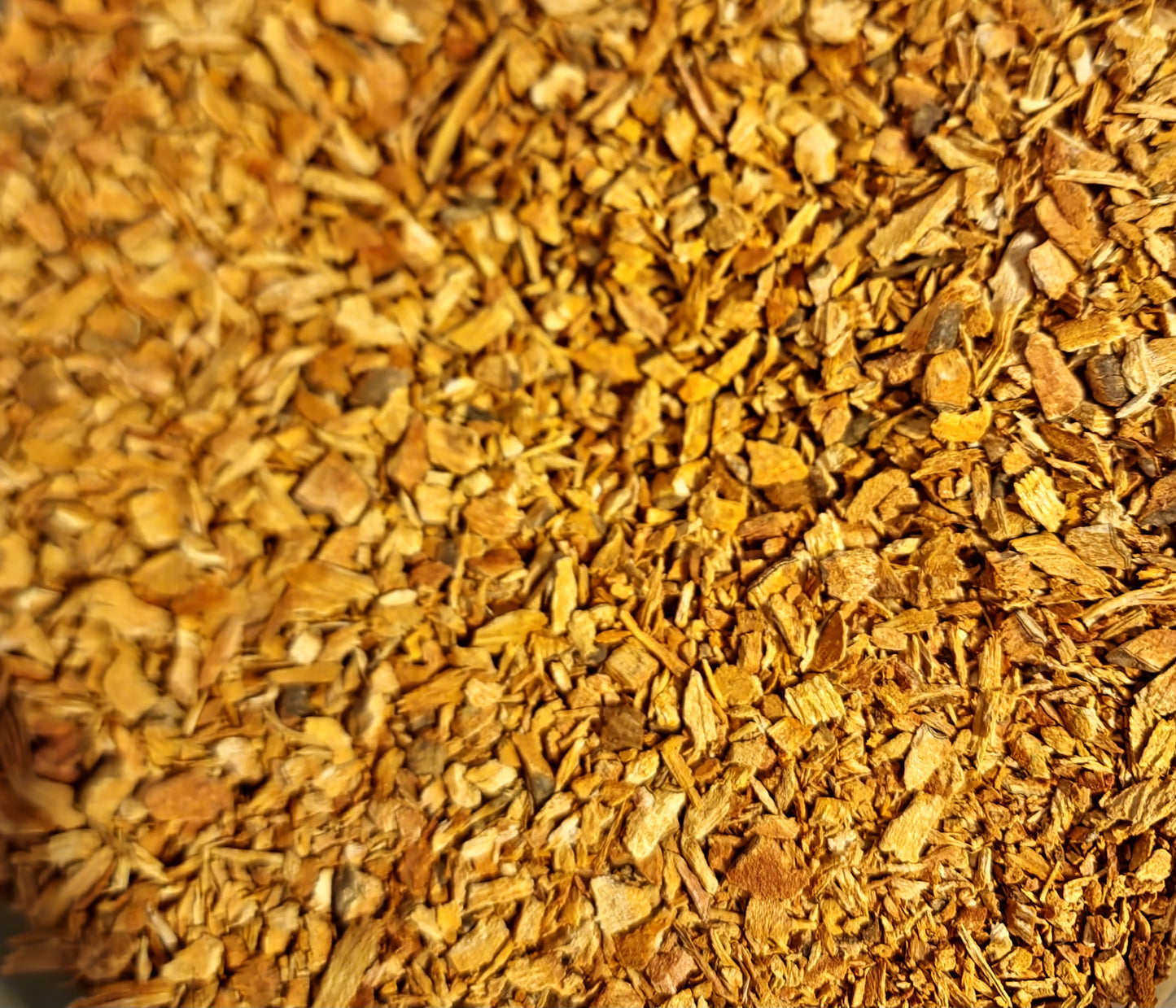 A detailed overhead macro view of loose Apothecary Grade Chinese Sarsaparilla Root pieces, displaying the clean cut, starchy pinkish-brown inner core and rustic bark of premium dried Smilax china (China Root).
