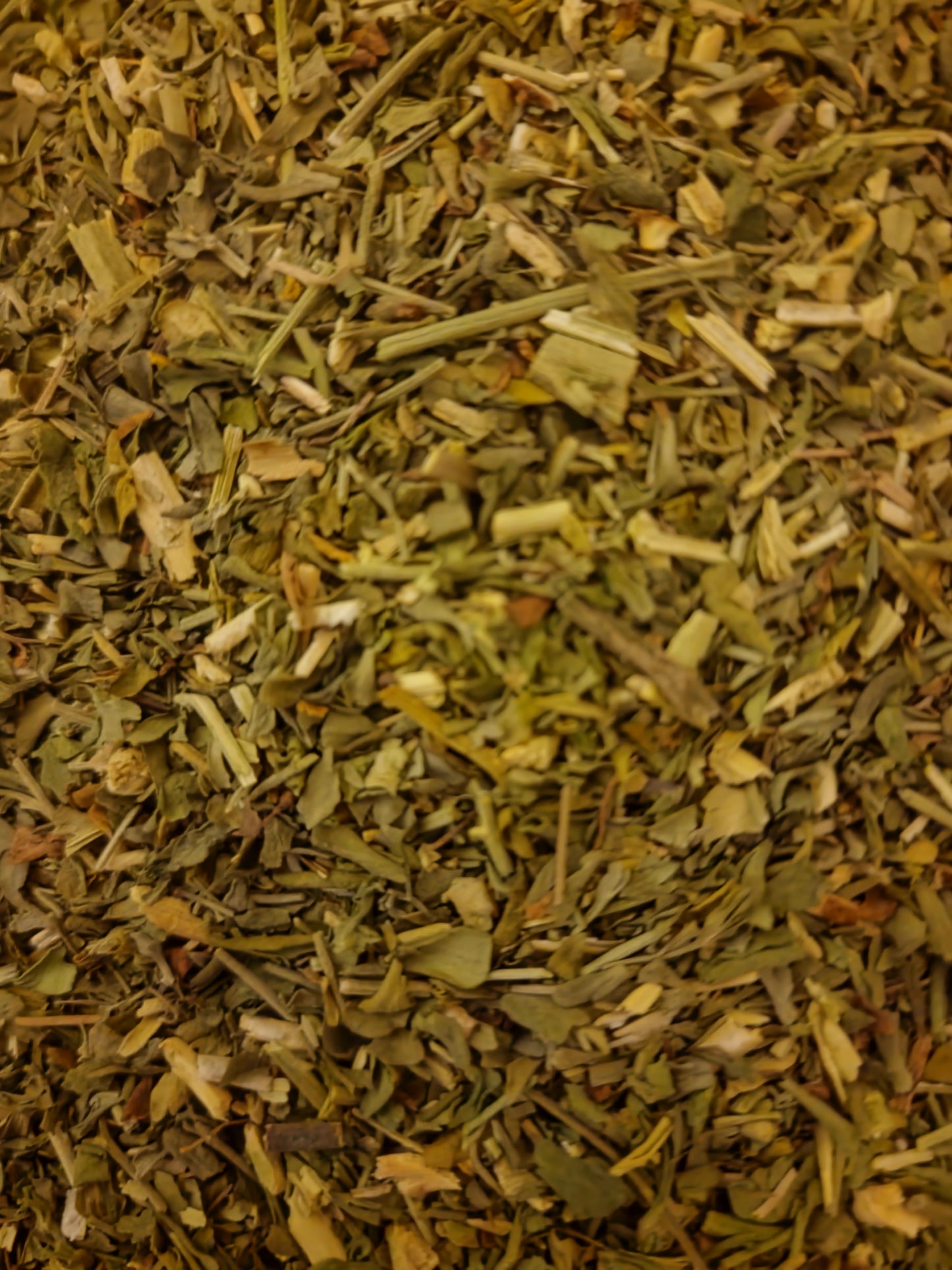 An overhead macro photograph of loose Apothecary Grade dried Rue Herb, displaying the cleanly cut pale sage-green to khaki leaves and aerial parts of premium Polish Ruta graveolens.