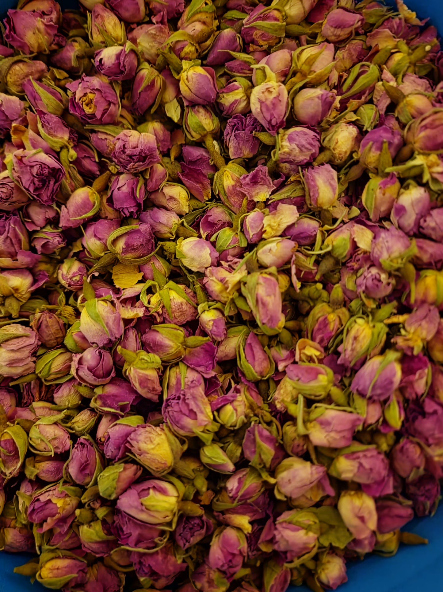 A highly detailed macro close-up of whole, dried Premium Pink Rose Buds (Rosa centifolia), also known as the Apothecary Rose. The image beautifully showcases their vibrant magenta-pink petals, intact structure, and exceptional purity, ideal for traditional holistic herbal infusions and high-end botanical crafting.