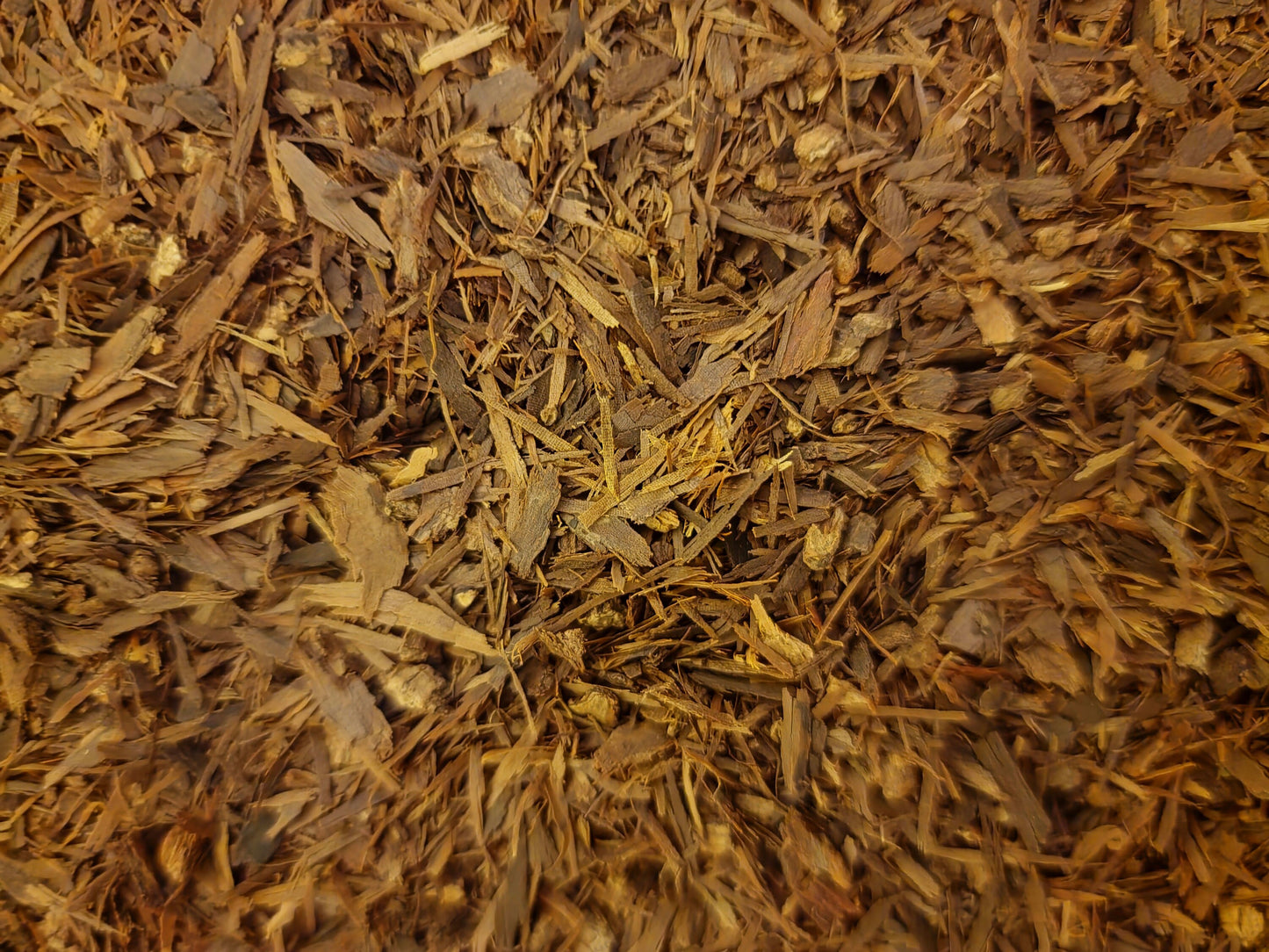 An overhead macro photograph of loose Apothecary Grade dried Pau D'Arco Bark, displaying the premium uniform mixture of earthy reddish-brown and dusty mahogany cut inner-bark shreds of sustainably wild-crafted South American Handroanthus impetiginosus.