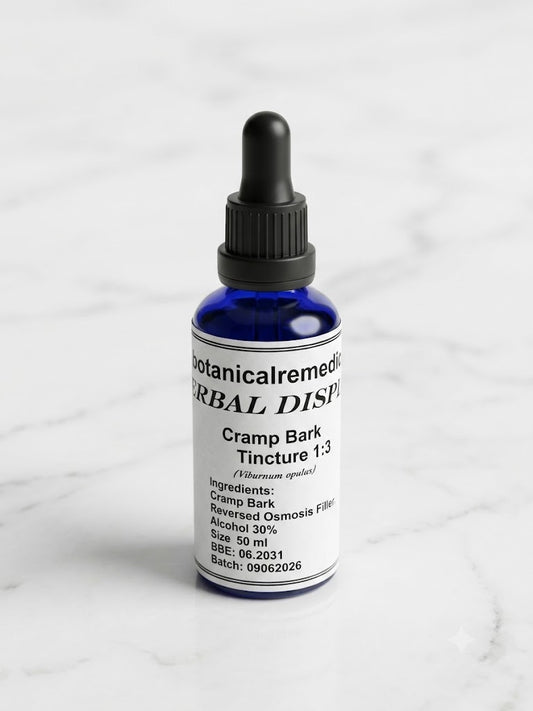 A 50ml cobalt blue glass dropper bottle of practitioner-grade Cramp Bark Tincture 1:3 (Viburnum opulus) by Botanical Remedies, standing upright on a clean, minimalistic white marble background with soft grey veining.