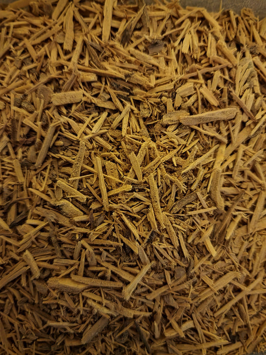 A high-definition top-down view of premium wildcrafted Muira Puama bark, showcasing cleanly cut, linear woody slivers with an authentic light tan and golden-brown fibrous texture