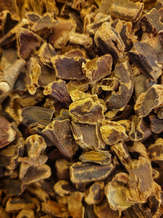 An overhead macro shot of loose Apothecary Grade broken Carob Bean Pods, displaying the rich, dark chocolate-brown color and thick fibrous texture of authentic Turkish Ceratonia siliqua