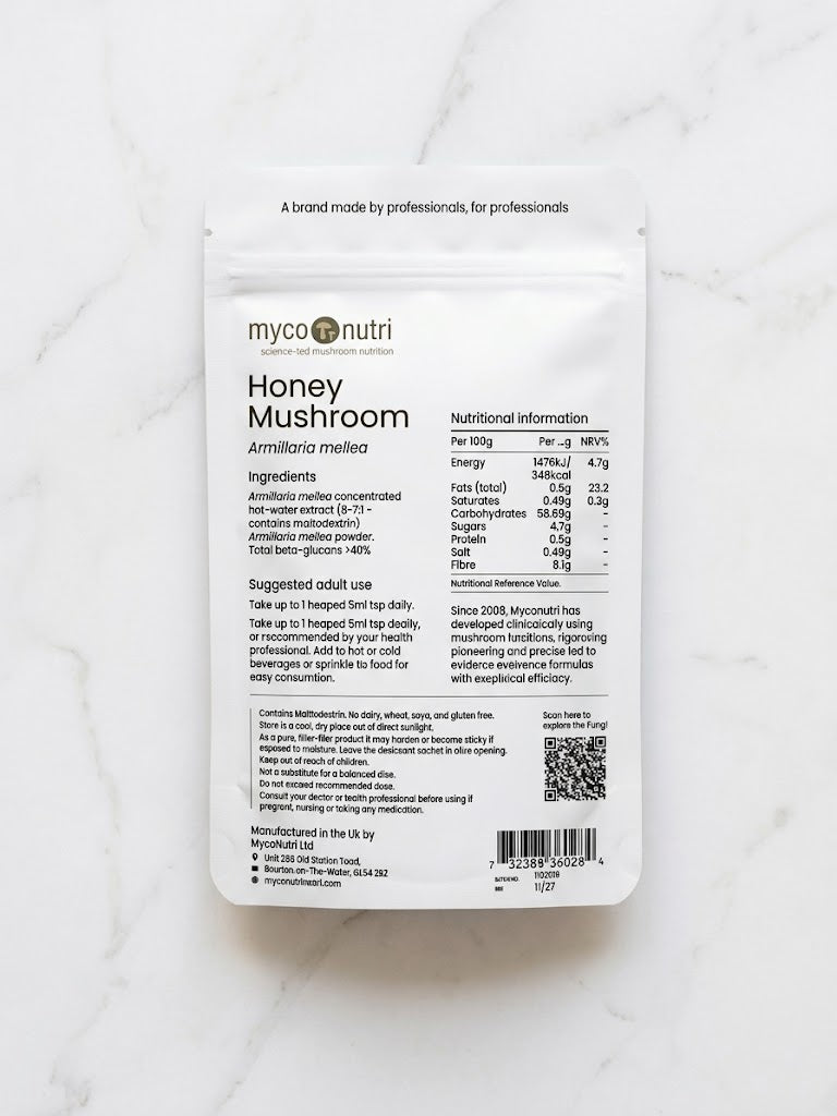 Back of MycoNutri Honey Mushroom powder pouch displaying ingredients, nutritional information, and practitioner dosage guidelines on a white marble surface
