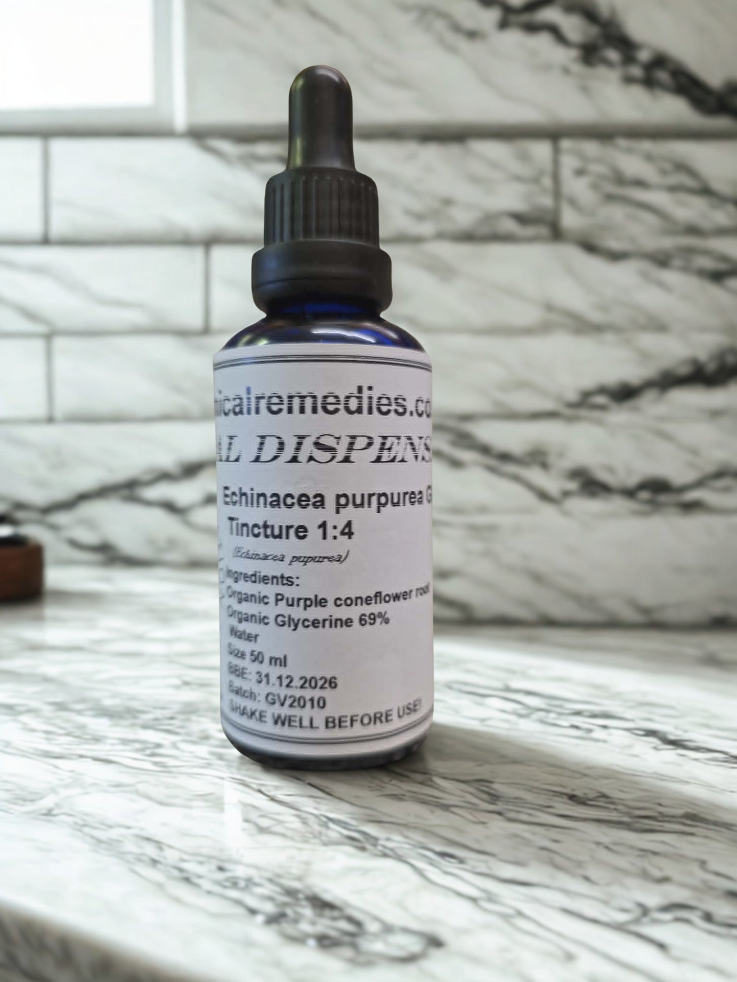 A 50ml blue glass dropper bottle of Botanical Remedies Organic Echinacea purpurea Root Glycerite (1:4) resting on a white marble countertop