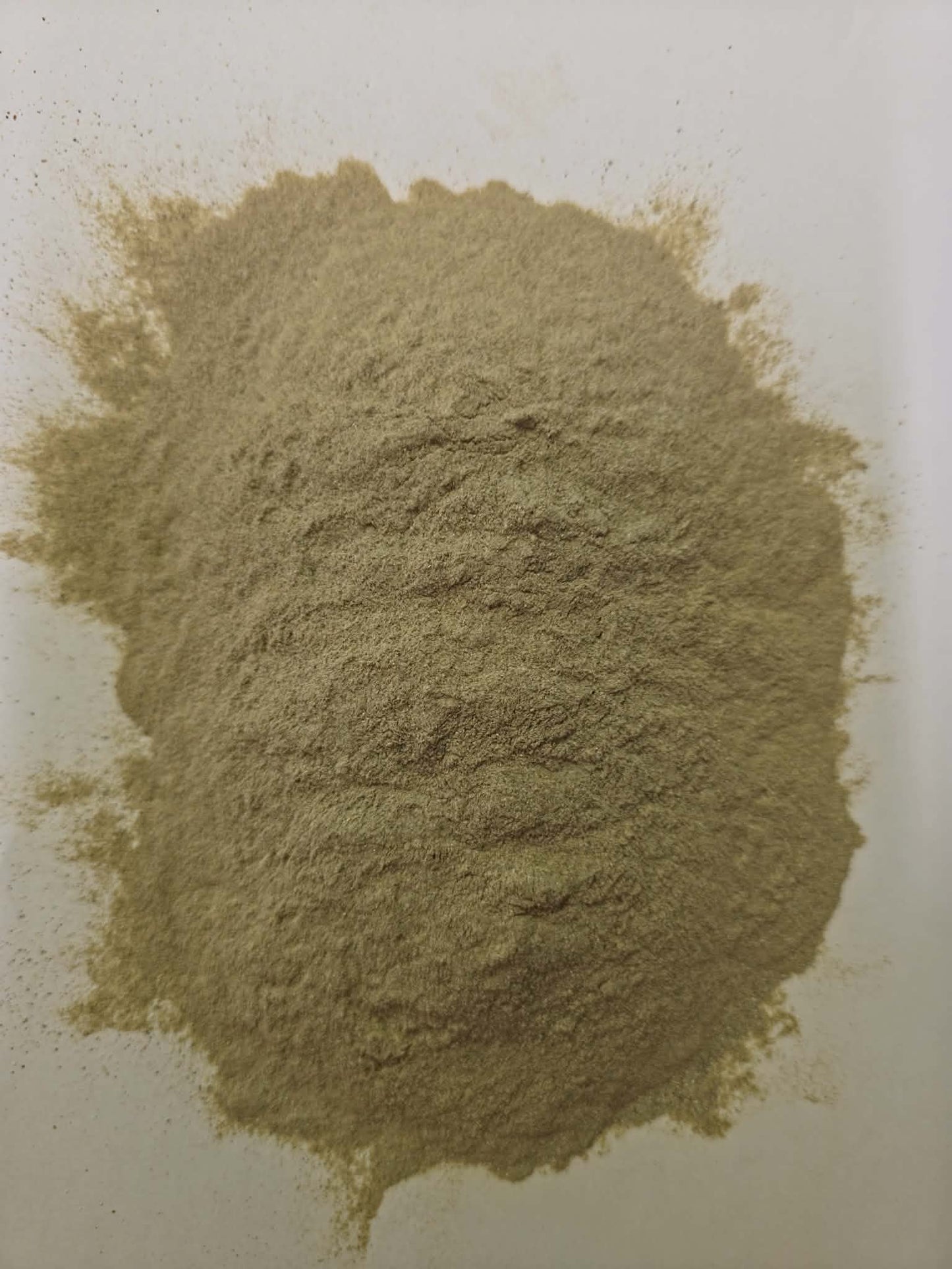 Pile of finely ground light brown organic Sitopaladi powder on a clean white background