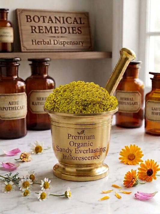 A luxurious close-up photograph of a golden brass apothecary mortar filled overflowing with vibrant golden-yellow Premium Organic Sandy Everlasting (Helichrysum arenarium) inflorescences. The flower heads are dense, uniform, and meticulously destemmed, showcasing pristine botanical purity. The mortar front is engraved with 'Premium Organic Sandy Everlasting Inflorescence'. It rests on a marble table surrounded by scattered chamomile, calendula, and rose petals, with vintage apothecary jars and a 'Botanical 