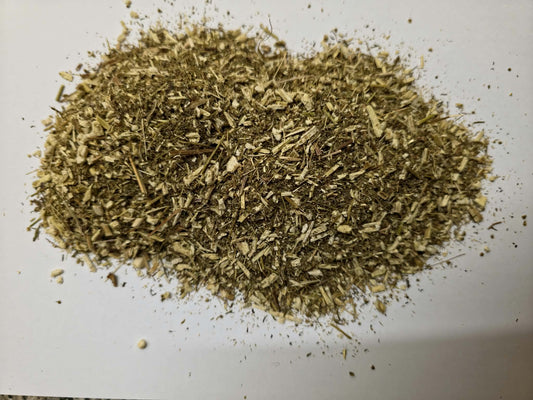 A top-down view of loose dried Sweet Wormwood herb cut segments (Artemisia annua), displaying a uniform matrix of greenish-brown dried leaves and stem cuts.