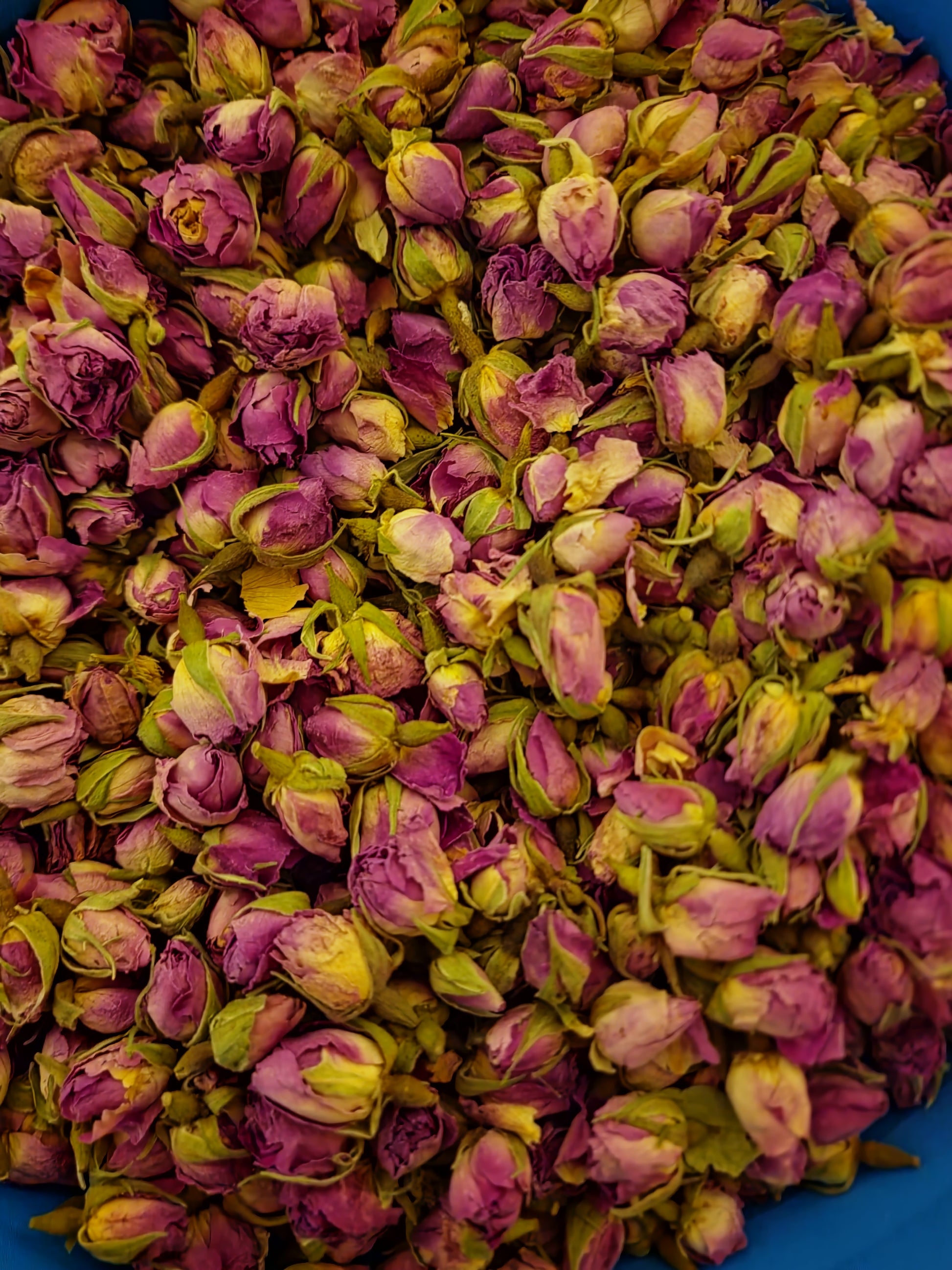 A highly detailed macro close-up of whole, dried Premium Pink Rose Buds (Rosa centifolia), also known as the Apothecary Rose. The image beautifully showcases their vibrant magenta-pink petals, intact structure, and exceptional purity, ideal for traditional holistic herbal infusions and high-end botanical crafting.