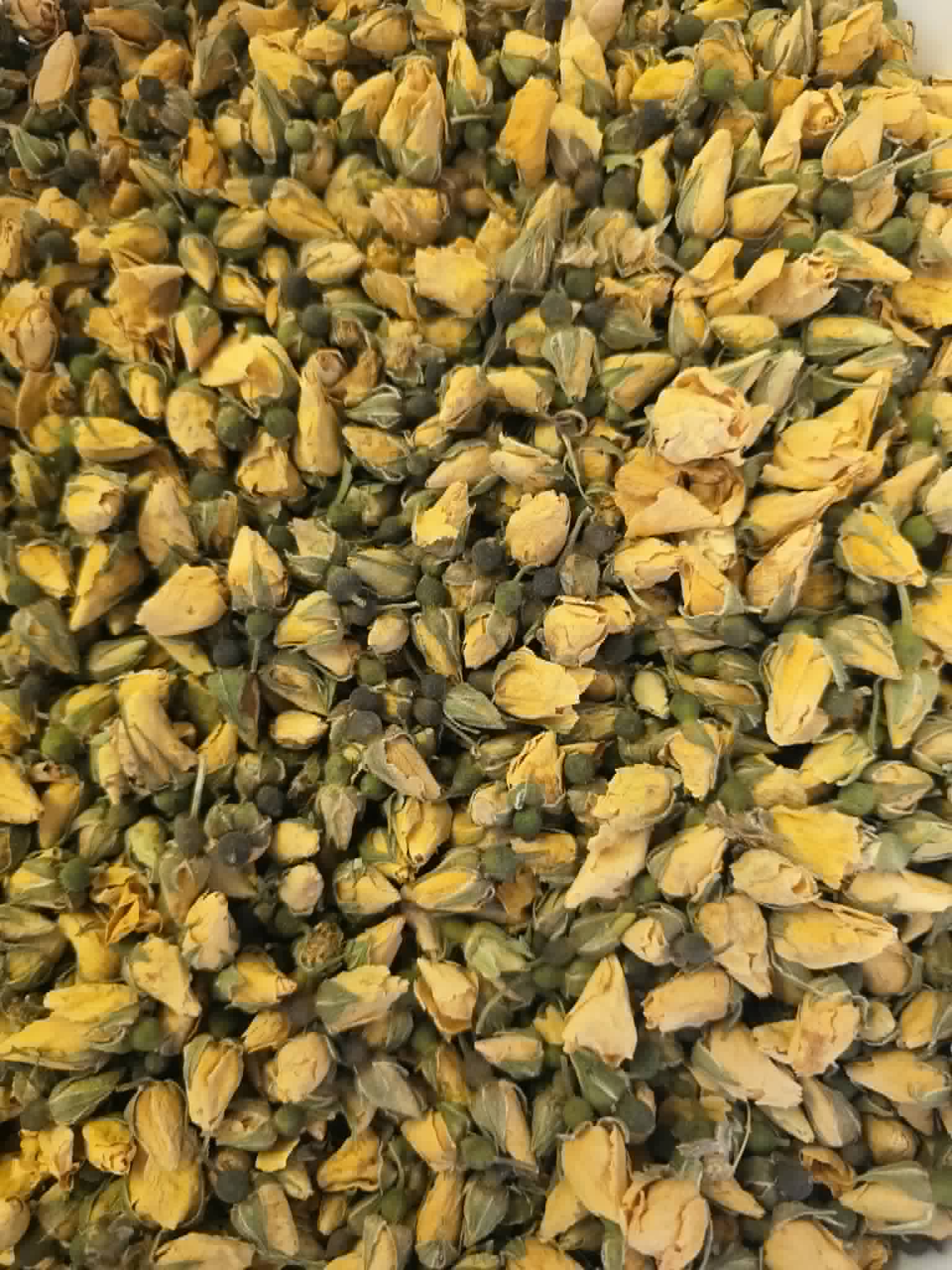 A detailed macro close-up of premium whole dried Yellow Rose Buds (Rosa damascena), showcasing their tightly closed vibrant yellow petals, intact green sepals, and pristine apothecary-grade quality for herbal infusions.