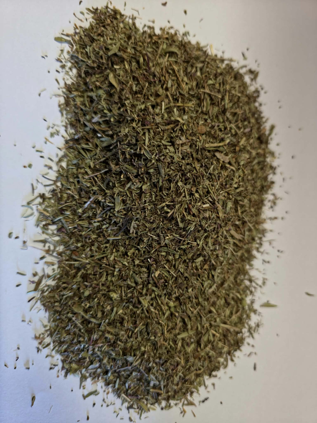 Ethically wild-crafted dried Winter Savory leaf cut (Satureja montana) from Albania displaying finely cut olive-green leaf and petiole fragments for tea infusions and culinary seasoning.